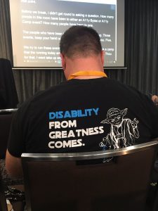 David Masters wearing shirt with image of Yoda and has a quote disability from greatness comes